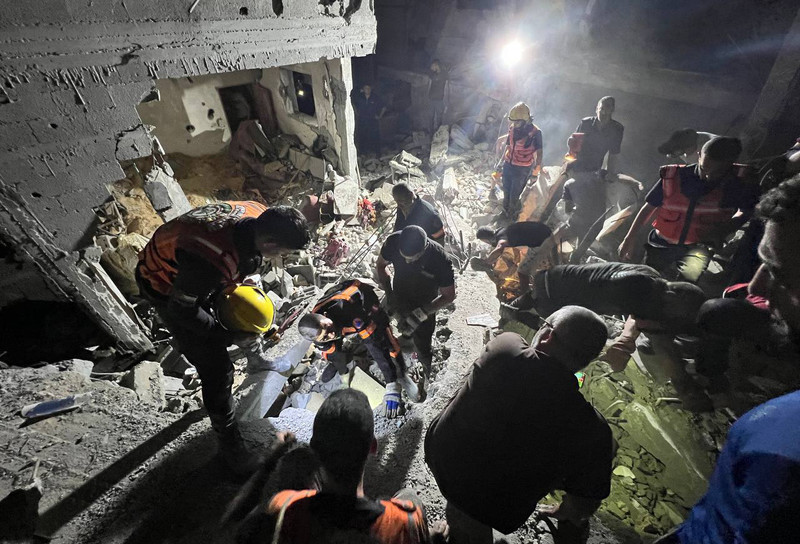 Palestinian rescue crews search for survivors in the rubble of a residential building following an Israeli airstrike in Rafah in the southern Gaza Strip, 6 August 2022. Ashraf Ramadan