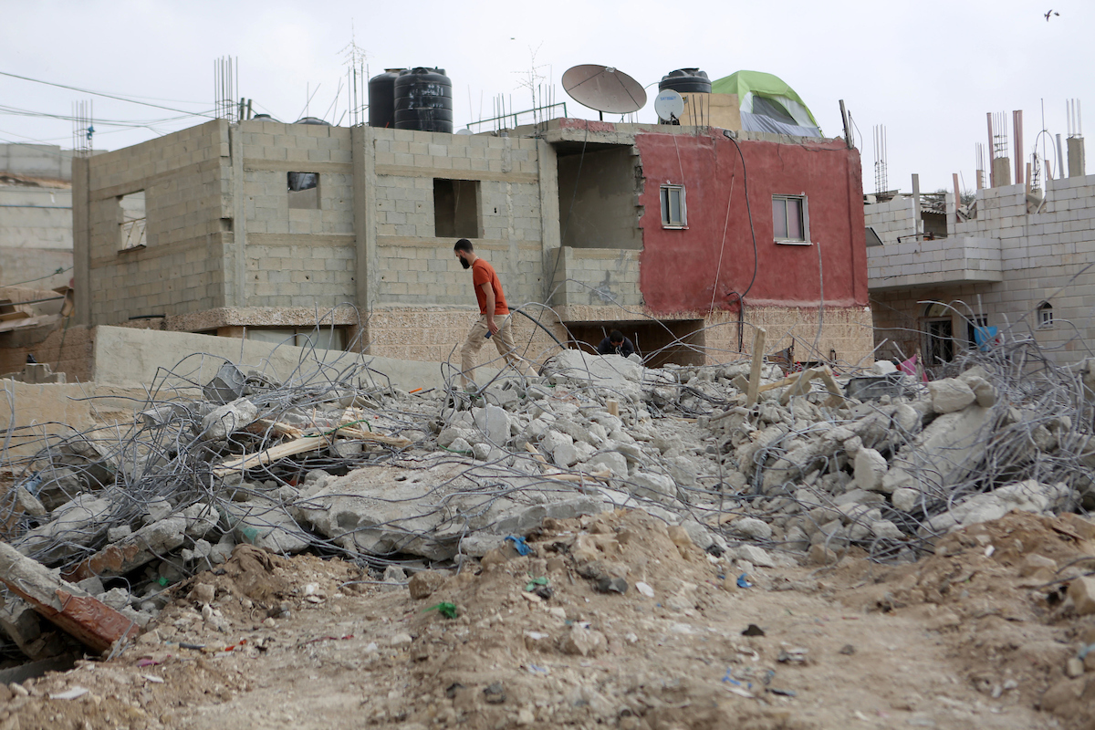 Palestinians stand on the rubble of their house that were demolished by the Israeli army, in the West Bank city Bireh, on October 18, 2018. The owners of the house said they were informed by the Israeli army that the demolition was carried out because they did not have an Israeli-issued construction permit. Photo by Shadi Hatem