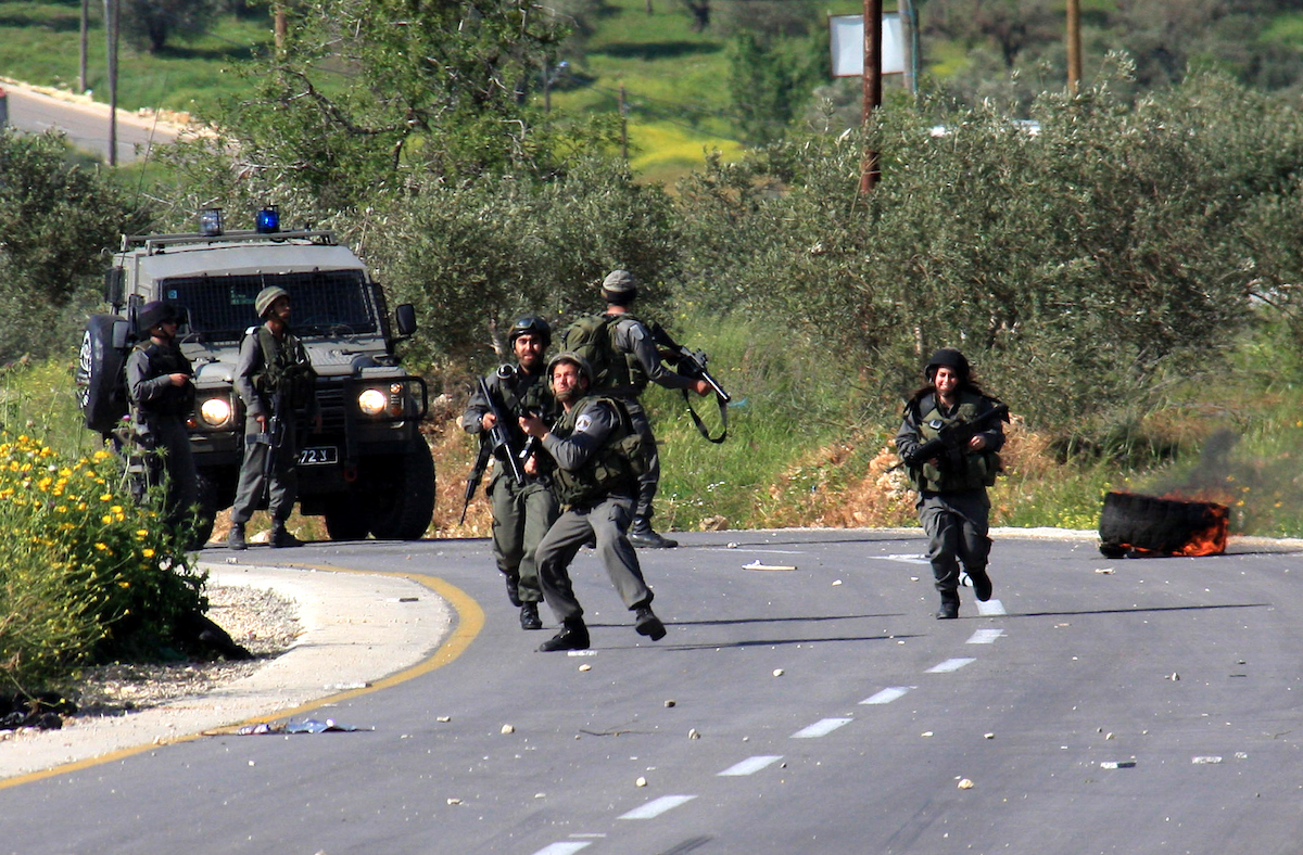 Israeli border policemen run towards Palestinian stone-throwers during clashes outside the West Bank Palestinian village of Awarta near the West Bank city of Nablus.