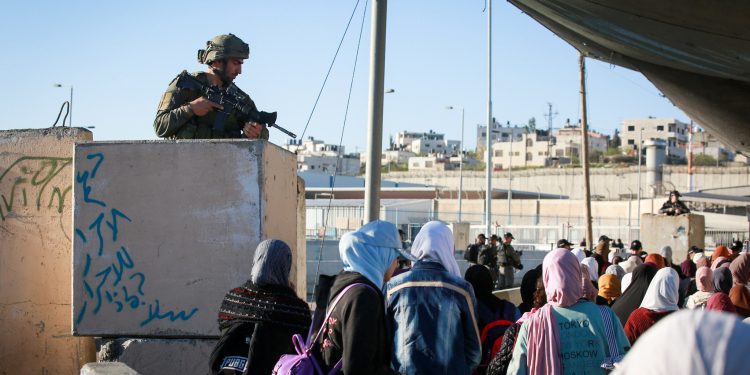 Palestinian women cross the Qalandiya checkpoint, outside of the West Bank city of Ramallah, on April 15, 2022. (Flash90)
